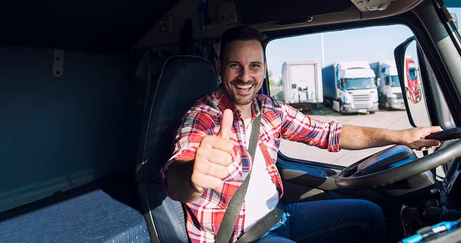 motorista sentado dentro de caminhão fazendo sinal positivo com a mão feliz com o transporte de carga seguro e eficiente